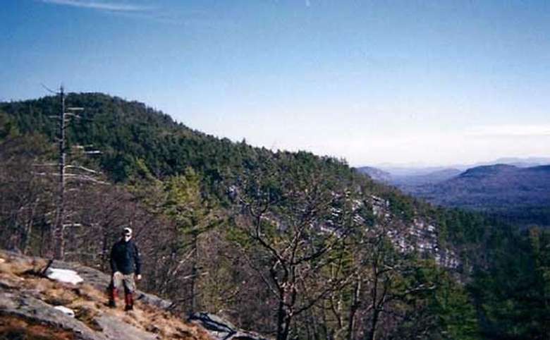hiker standing on a mountain summit