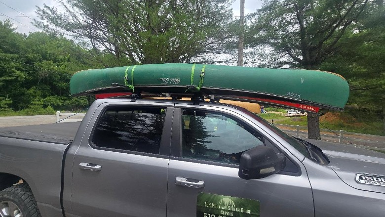 a truck with a green canoe on top