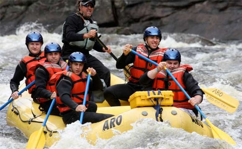 rafting group dressed in black long sleeved gear on the river