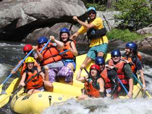 large group of whitewater rafters on a yellow raft