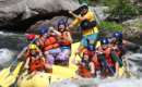 large group of whitewater rafters on a yellow raft