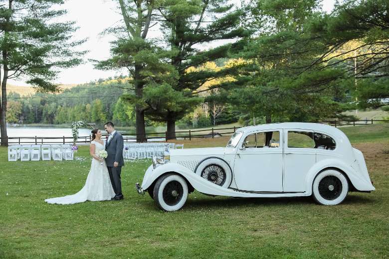 bride and groom by old fashioned car