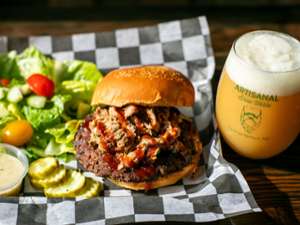 a smash burger with salad, and a hazy IPA beer