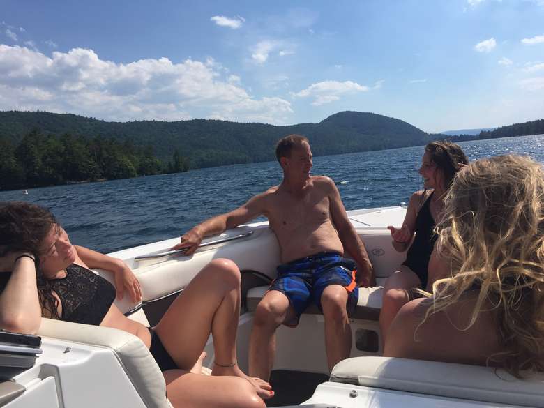group of friends chatting in a boat on lake george