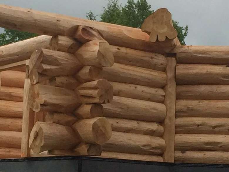 a pile of logs stacked, looks like it's going to be a house