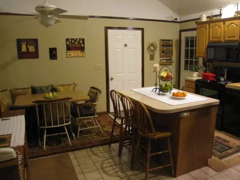 side view of the kitchen island and a seating area with two chairs and a bench
