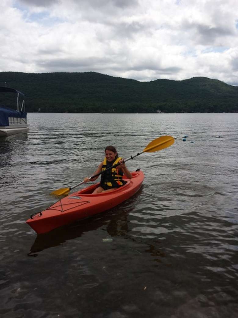 girl paddling a kayak on lake george