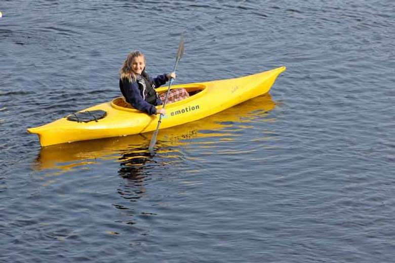 woman paddling a yellow kayak