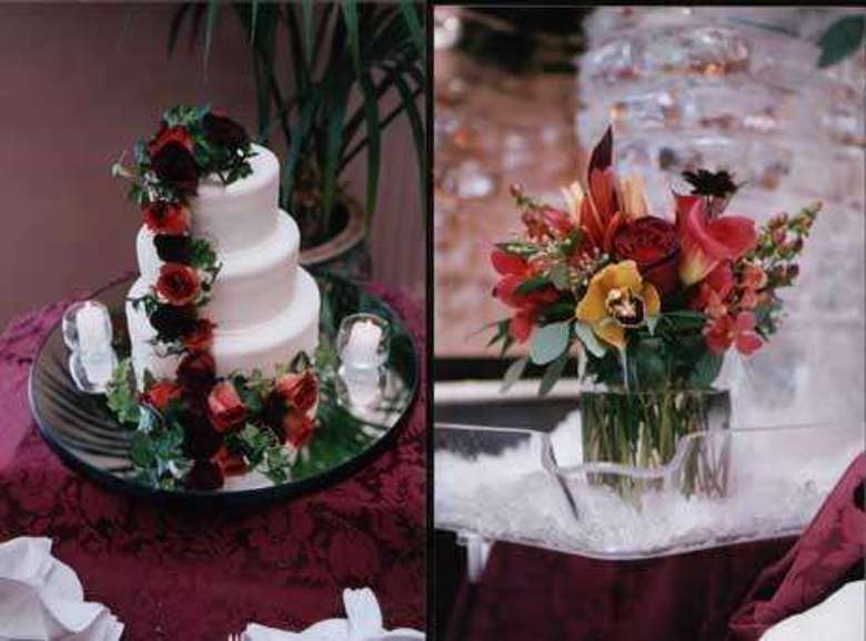 three tiered cake with flowers on it and a small vase of flowers