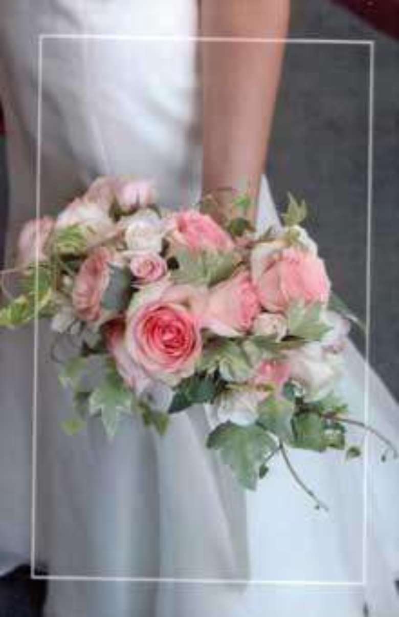 bride holding a bouquet of pink roses