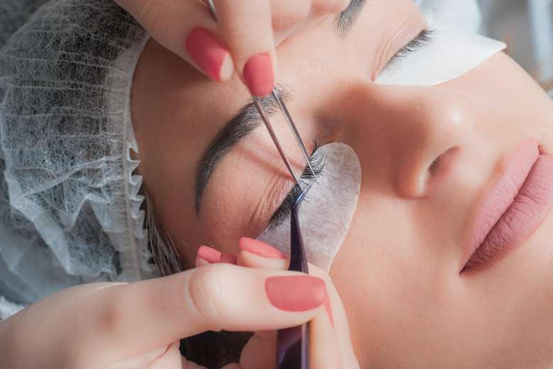 woman having eyelashes brushed