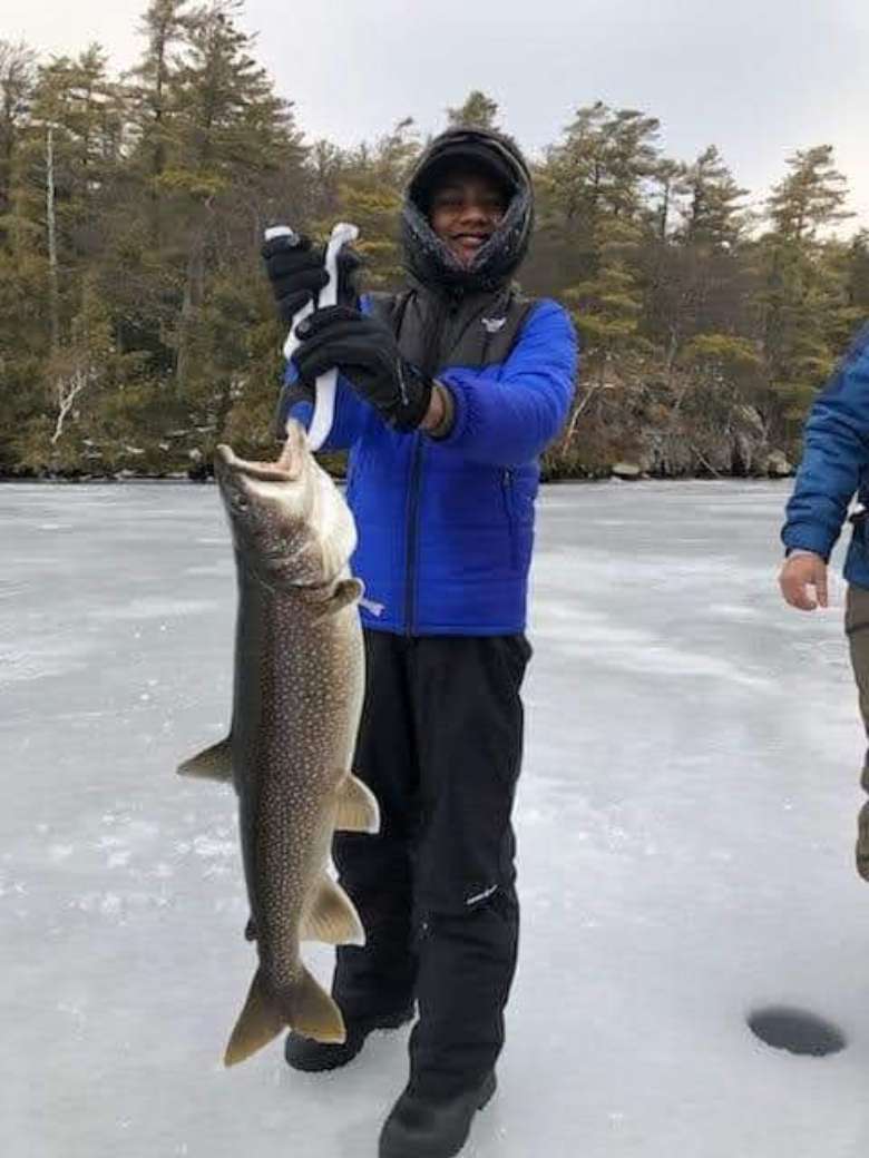 kid with fish in winter