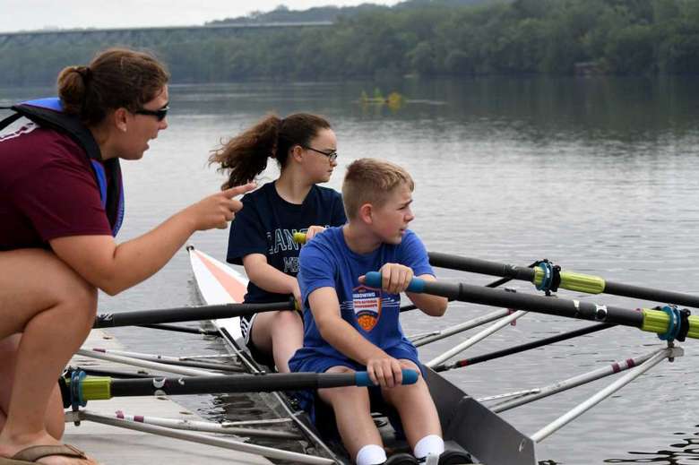 WWoman giving instruction to kids who are rowing