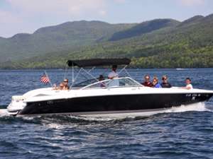 motorboat on lake george with mountains in the background