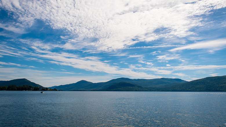 view of a lake on a sunny day with mountains in the background