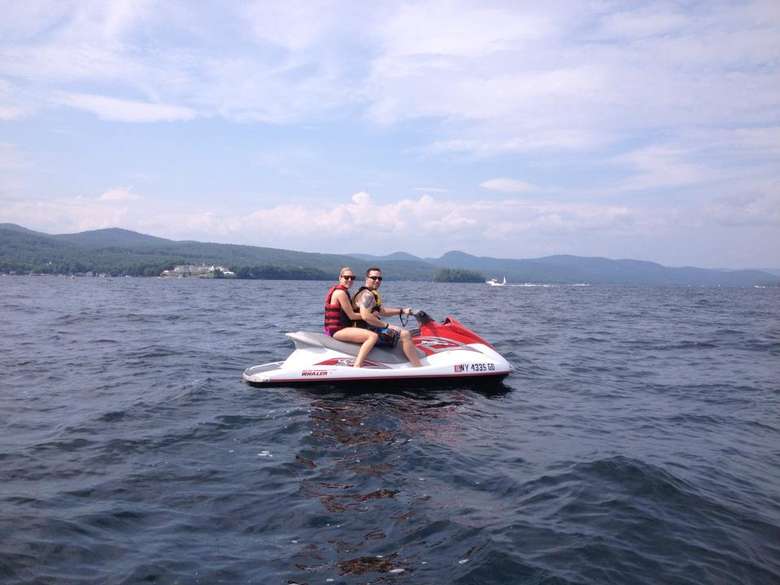 a man and a woman riding on a jet ski in the middle of a lake