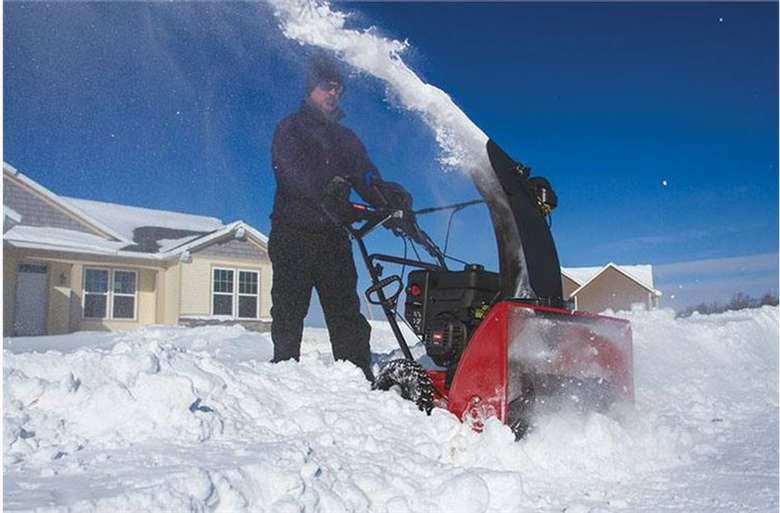 a man pushing a snow thrower