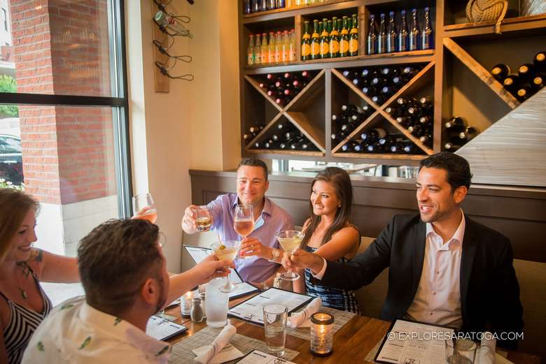 a group of five people clinking glasses together