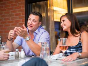 a man sitting next to a woman at an outdoor patio table