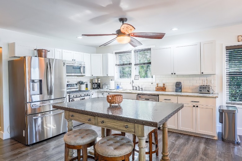 The main level (middle floor) has an open floor plan with a fully equipped kitchen. A large island with 4 stools. Lakeview from the windows Kitchen