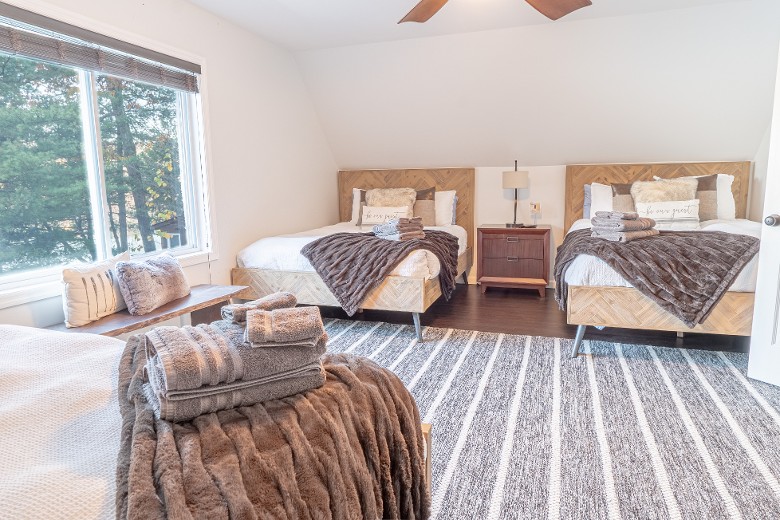 The third-level bedroom features 3 queen beds. Stunning lake views! Bedroom 4