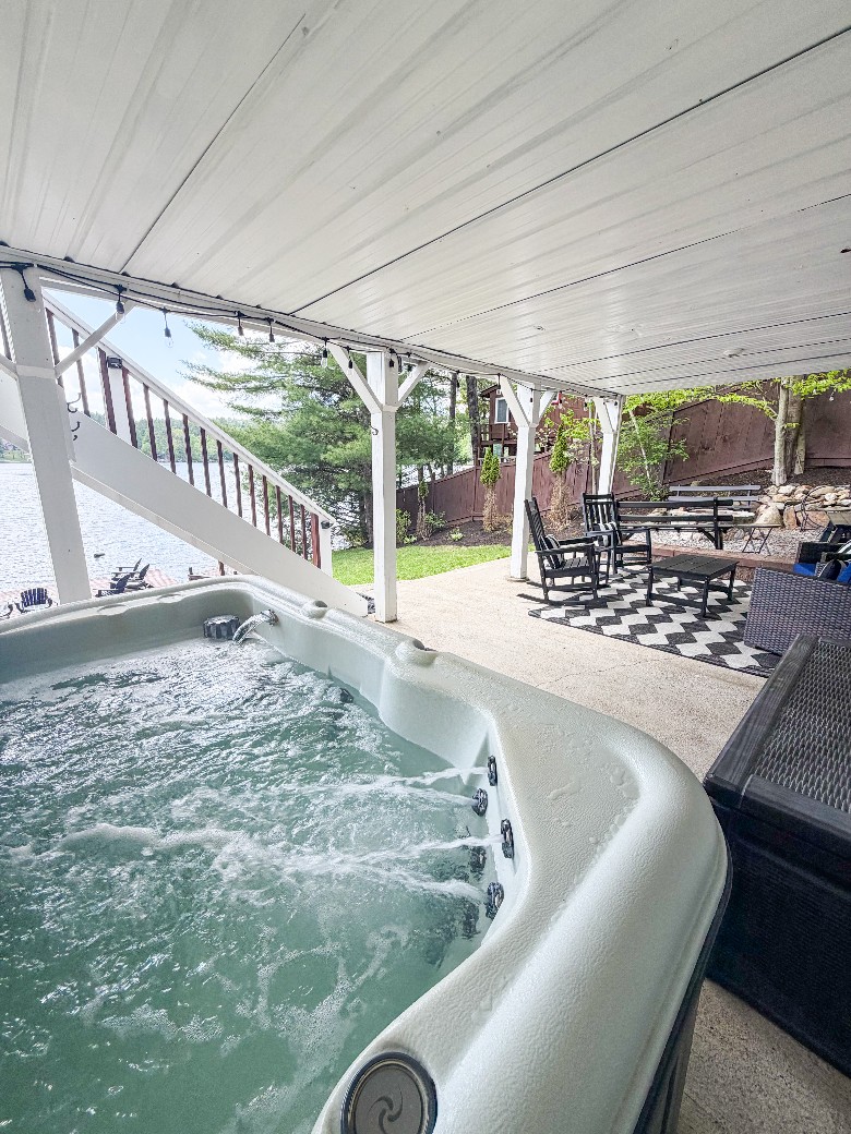 Lake-level patio area with hot tub and seating, close to the firepit and outdoor shower