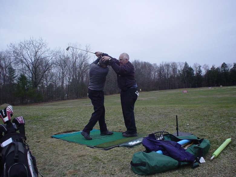 Man instructing another man on how to improve his golf swing