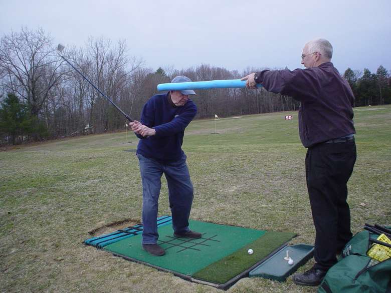 Man instructing another man on how to improve his golf swing