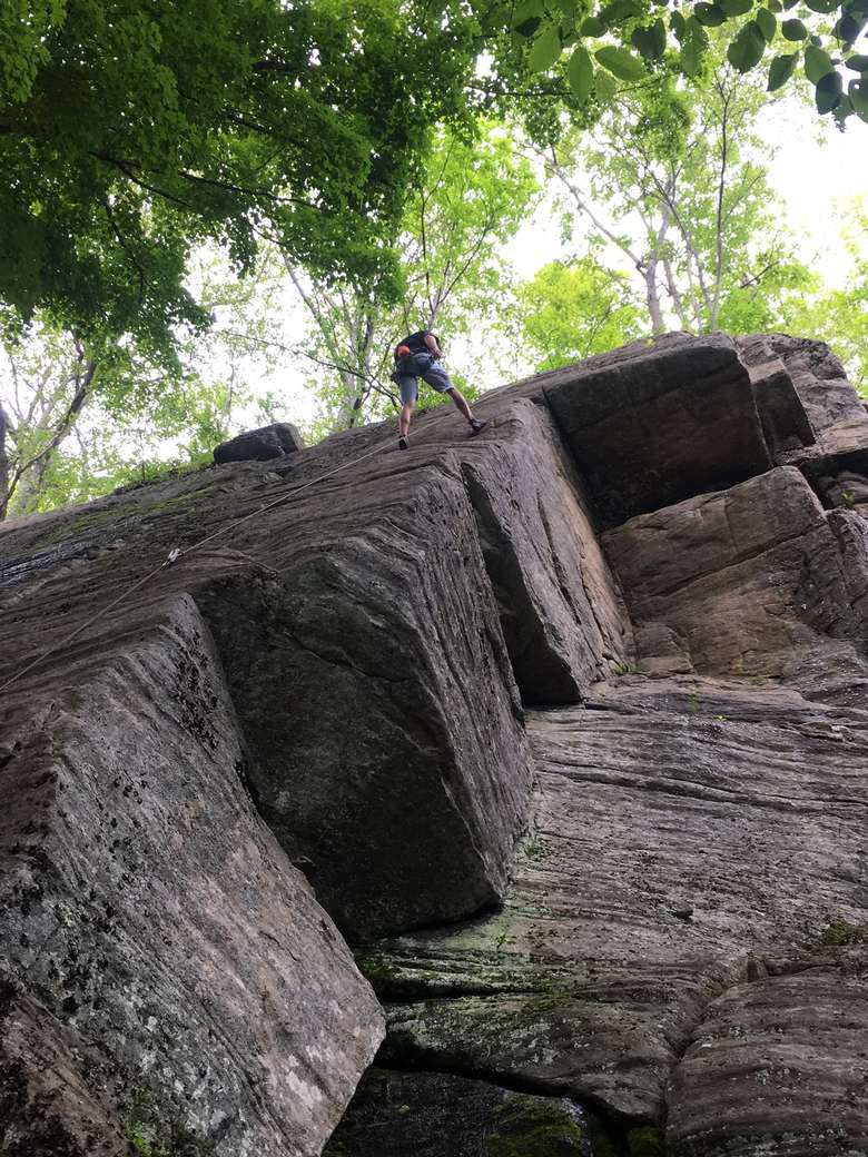 a man rock climbing up a steep rock
