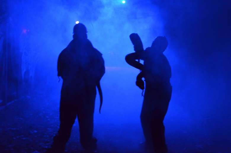 two people at horror attraction in a blue smokey light