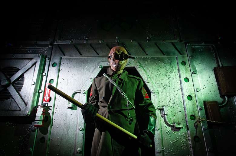 man dressed in trenchcoat at a horror attraction