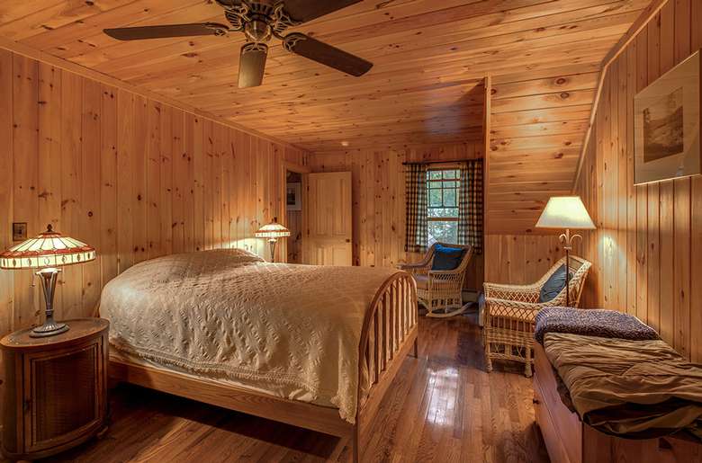 a furnished bedroom with wood paneling
