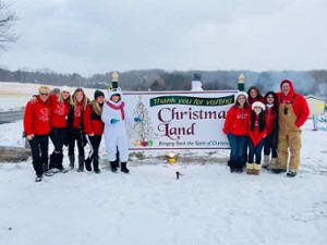 people near a christmas land llc sign
