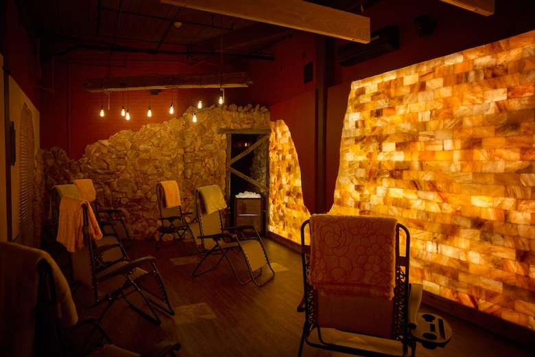 a man-made salt cave with lounge chairs and warm lighting