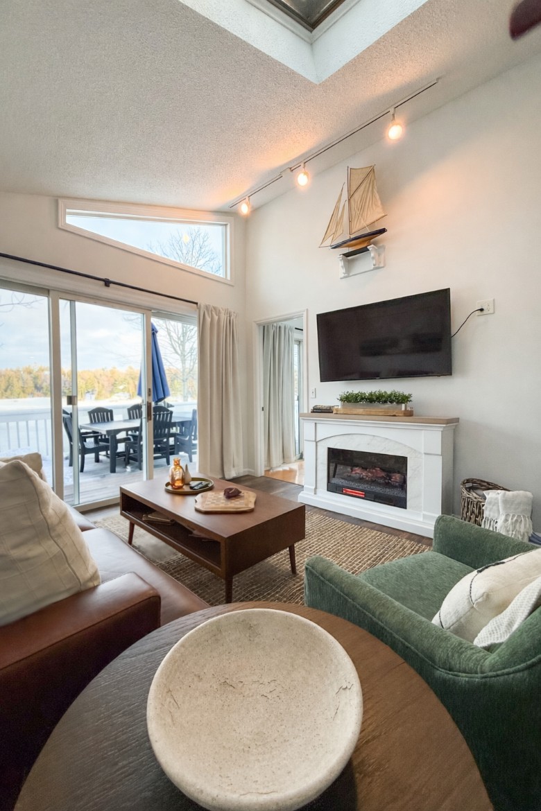 The main-floor living room, with lake views, features an electric fireplace. Walk out onto the upper deck and eat dinner overlooking the lake.