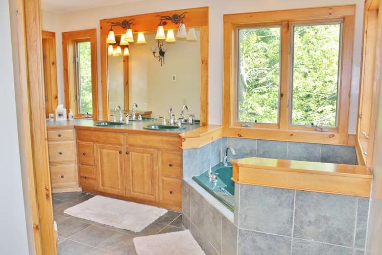 a large bathroom with a jacuzzi tub and sinks in the back