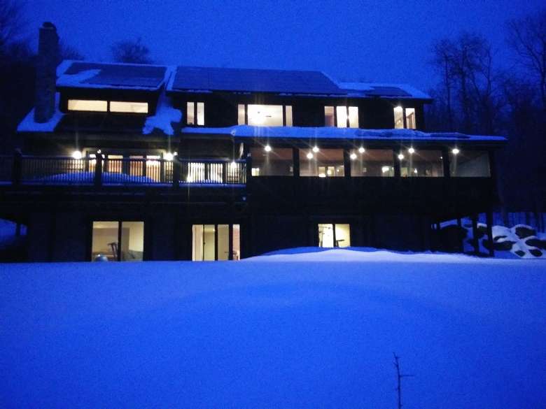 large home covered in snow in the evening