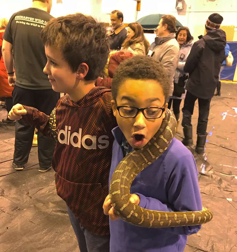 two little kids holding a snake