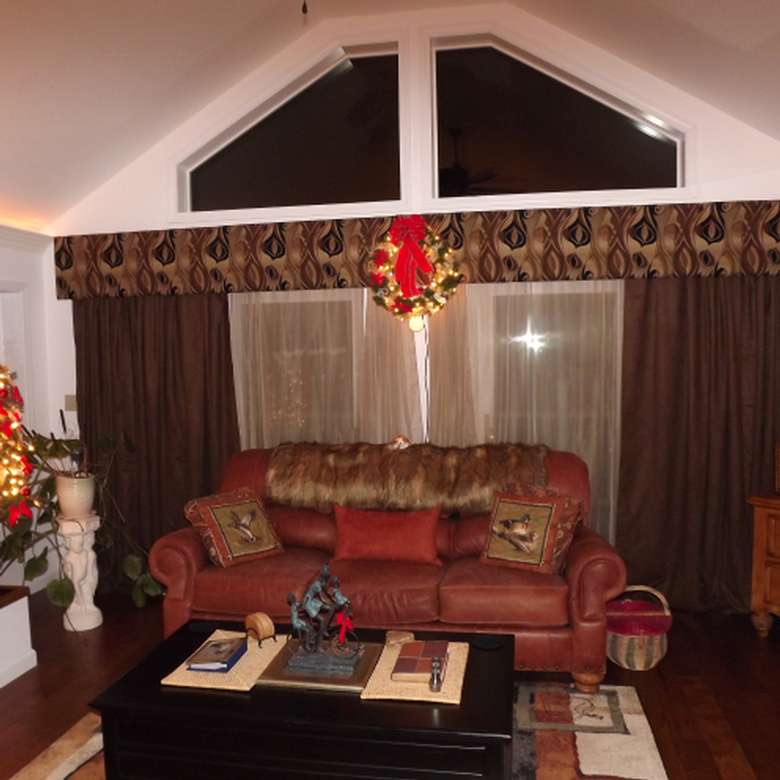 a wreath hanging above a red couch in a living room