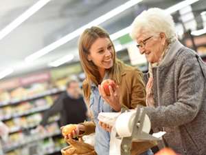 a woman helping an elderly woman with grocery shopping