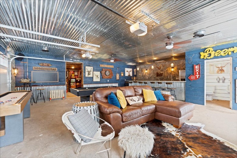 Bar/Gameroom located in the garage, with shuffle board, pool table, TV, and several arcade games!