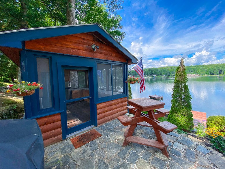 Kitchenette by the lake with a fridge, gas grill and seating. Enjoy the lake!