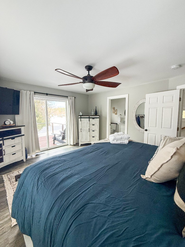 Upstairs king bedroom with attached bathroom and a balcony over looking the spacious yard and views of Hadlock Lake.