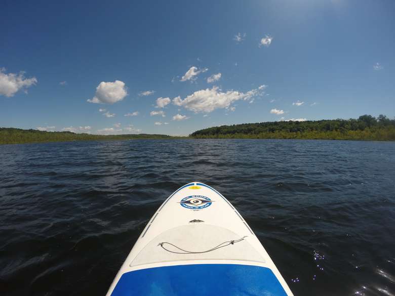 the front end of a stand up paddle board on the water