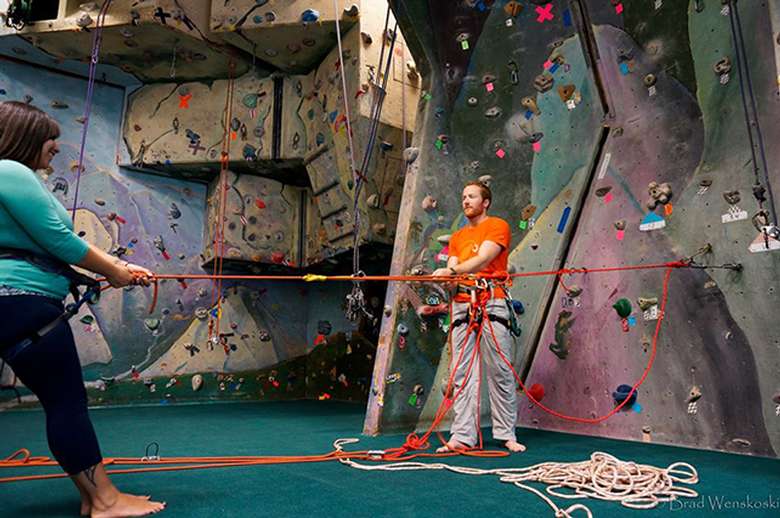 man and woman with ropes for indoor rock climbing