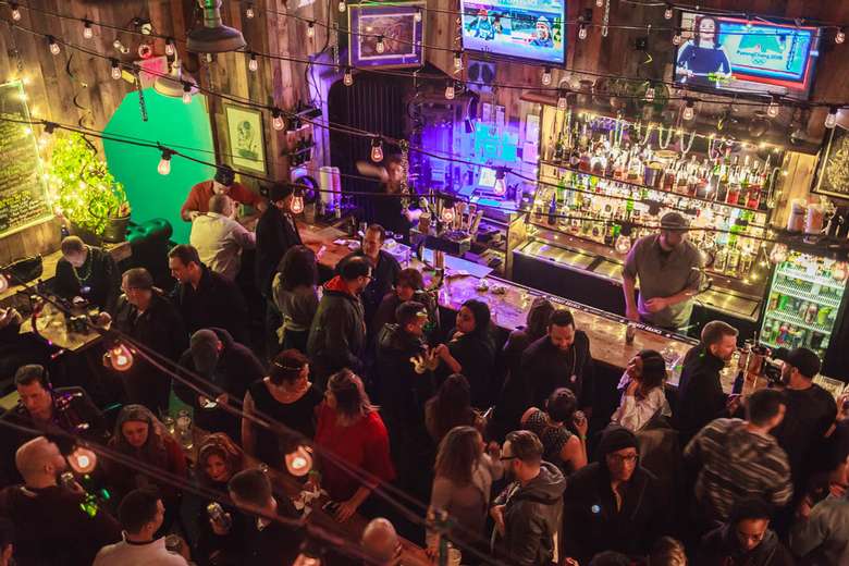 overhead view of crowd of people hanging out inside a bar area