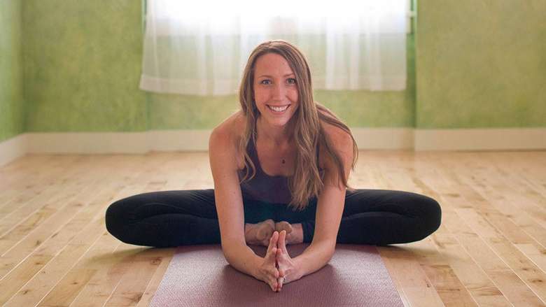 a woman in a yoga pose smiling