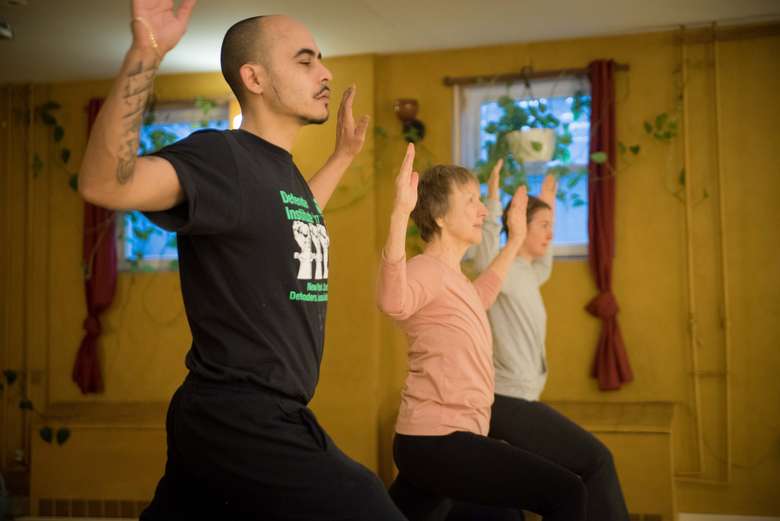 man and two women doing yoga