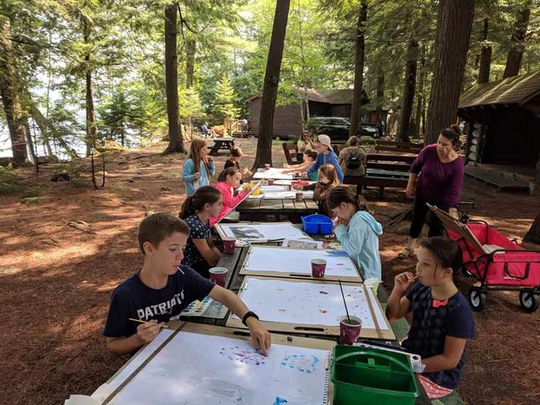 kids working on projects on tables outdoors