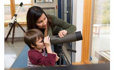 woman and boy checking out a telescope